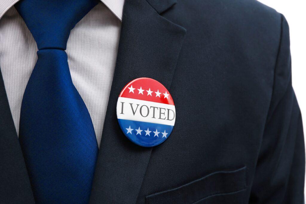 Ein Politiker mit einem Button mit der Aufschrift "I Voted".
