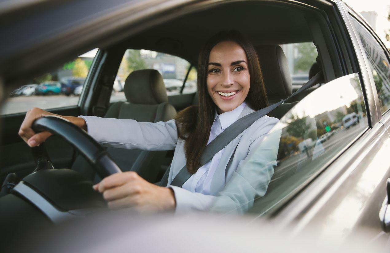 Eine selbstbewusste Fahrerin mit Sicherheitsgurt lenkt entspannt ihr Auto. Durch einen Fahrsicherheitskurs in Winterthur gewinnt sie mehr Kontrolle über winterliche Straßen.