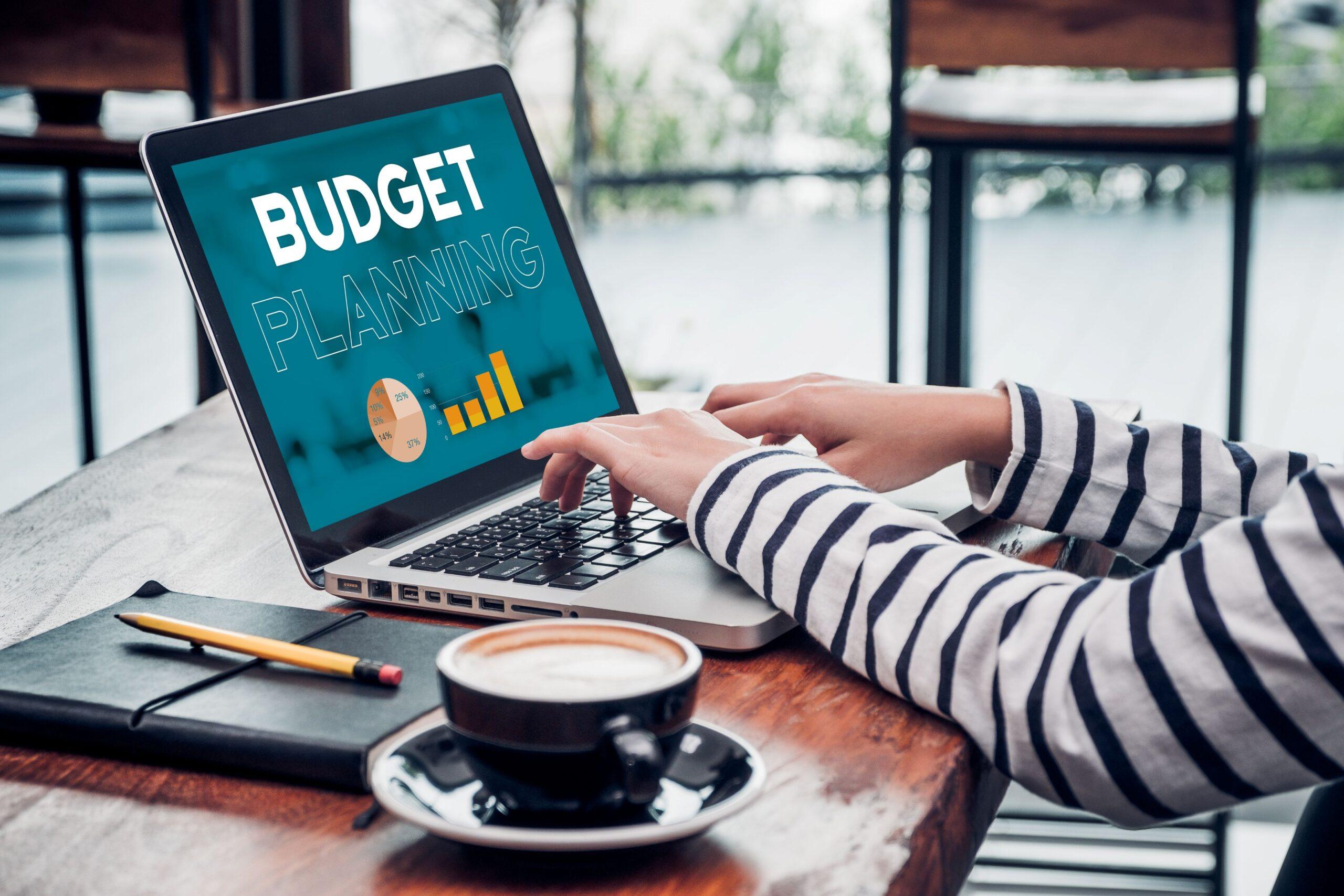 Person plant das Budget für eine Klassenfahrt nach München am Laptop