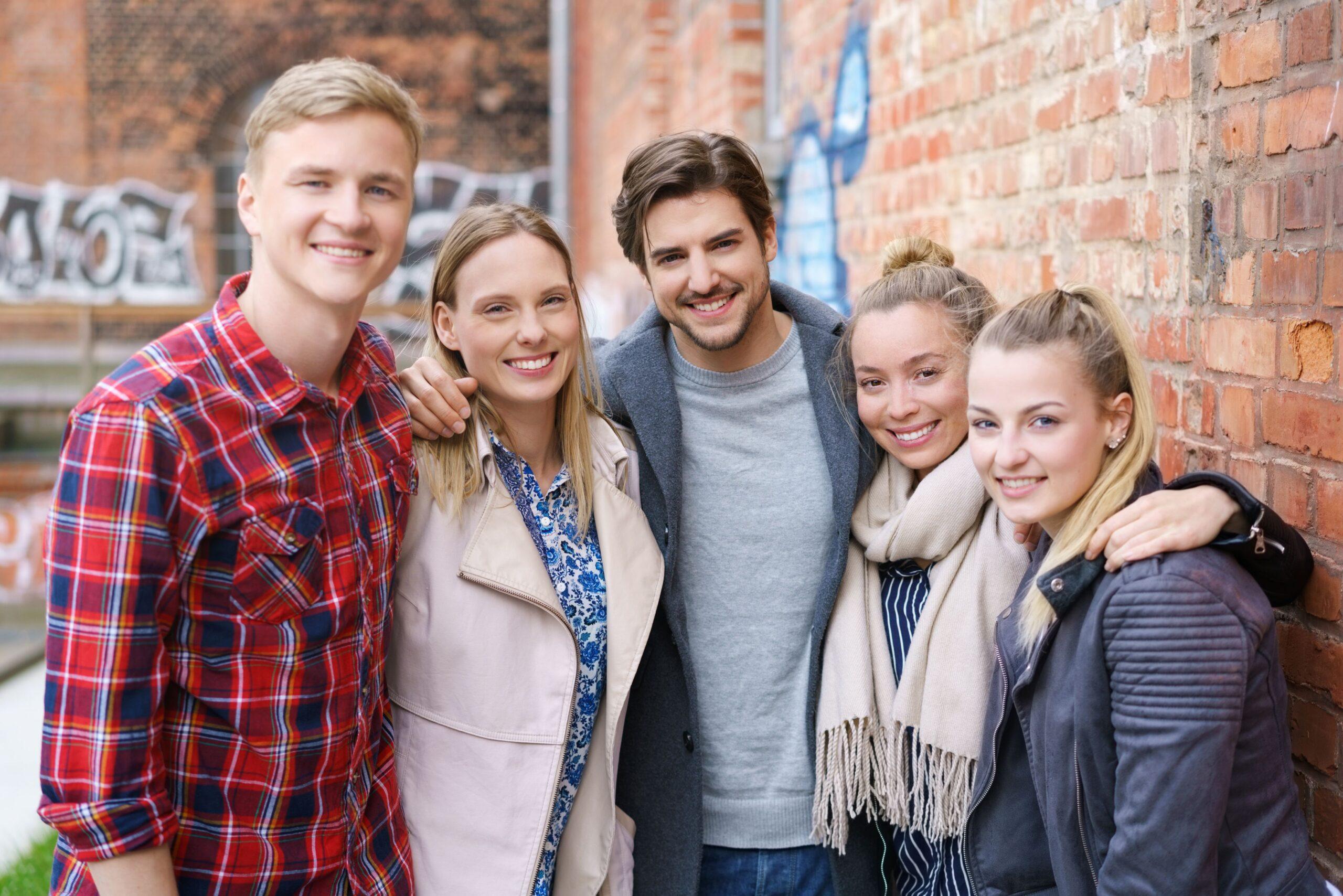 Gruppe von Jugendlichen steht eng zusammen und lacht