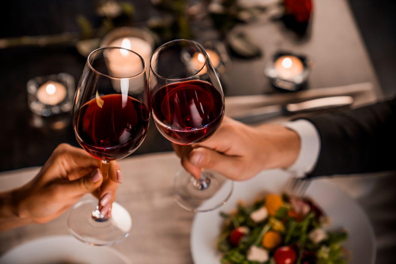 Nahaufnahme von zwei Glaesern Rotwein beim stilvollen Dinner – persoenliche Begegnung im Rahmen von Escort Dresden