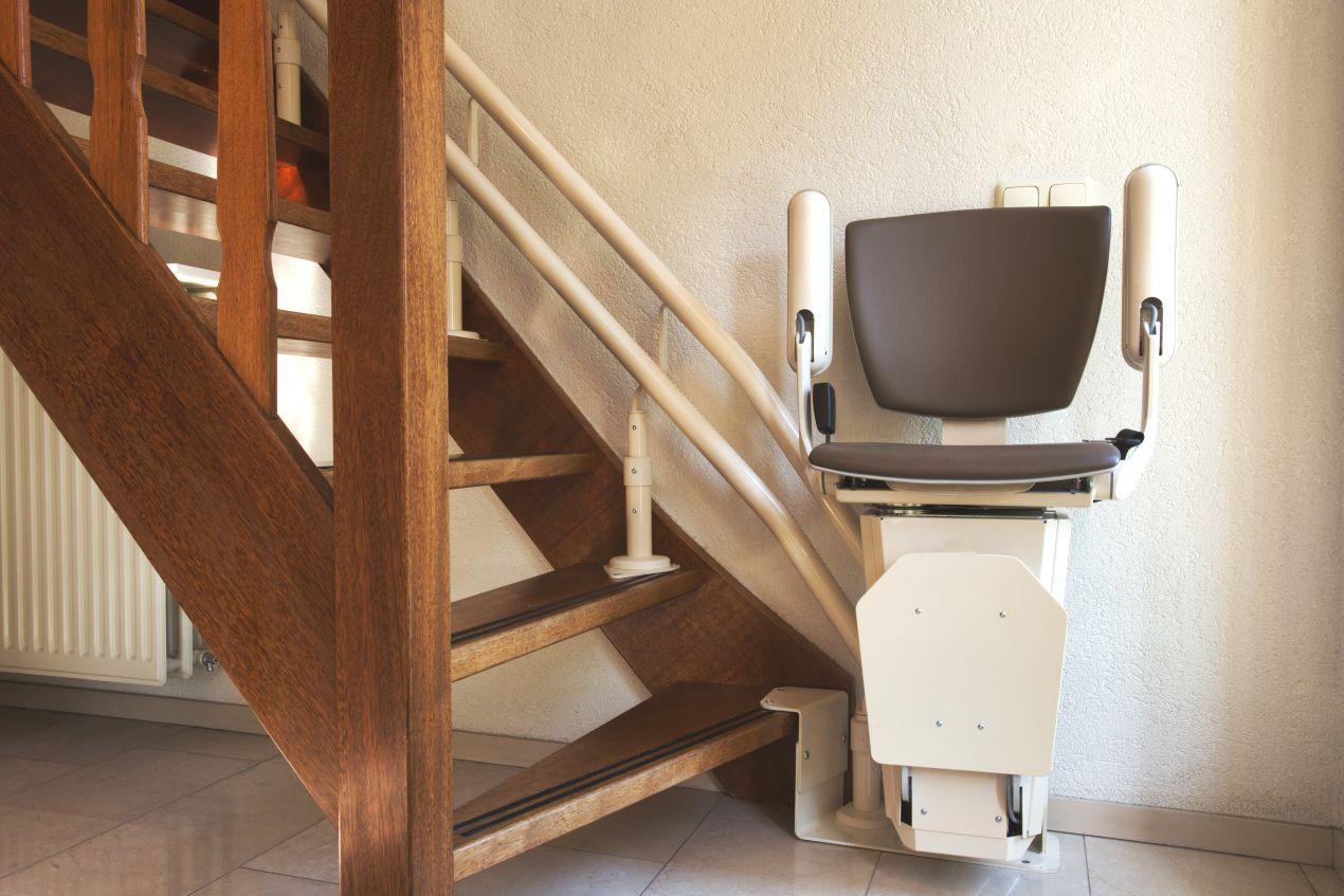 Kompakter Treppe Lift an einer gewendelten Holztreppe in einem privaten Wohnhaus