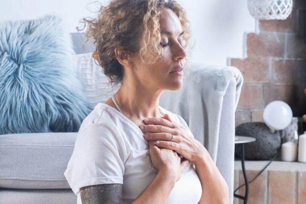 Frau schließt Augen und führt Atemübung zur Ruhe aus | Hypnose München